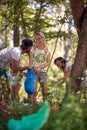 A group of young ecological activists are collecting the trash in the forest. Ecology, people, care