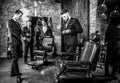 Group of young elegant positive mens pose in interior of barbershop.