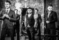 Group of young elegant positive mens pose in interior of barbershop.