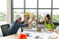 Group of young engineer team giving high five and celebrating success at office. Cheerful startup business team rejoicing success Royalty Free Stock Photo