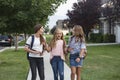 Group of young female friends and students talking together as they walk home school for the day