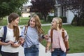 Group of young female friends and students talking together as they walk home school for the day