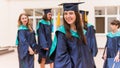 A group of young female graduates. Female graduate is smiling against the background of university graduates Royalty Free Stock Photo