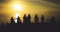 Group of young friends on background beach ocean sunrise, silhouette romantic people dances looking on rear view evening seascape Royalty Free Stock Photo