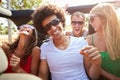 Group Of Young Friends Dancing In Back Of Open Top Car