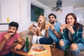 Group of young friends eating pizza and watching tv. Royalty Free Stock Photo