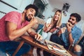 Group of young friends eating pizza and watching tv.Home party. Royalty Free Stock Photo