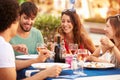 Group Of Young Friends Enjoying Meal In Outdoor Restaurant