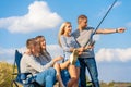 Group of young friends fishing on the pier by lakeside Royalty Free Stock Photo