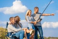 Group of young friends fishing on the pier by lakeside Royalty Free Stock Photo