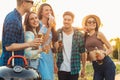 Group of young friends having barbecue party in nature, friends fry meat, chat and drink lemonade outdoors Royalty Free Stock Photo