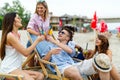 Group of young friends having fun at the beach on a sunny day. People vacation happiness concept. Royalty Free Stock Photo