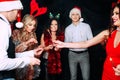 Party with friends. They love Christmas. Group of cheerful young people carrying sparklers and champagne flutes dancing Royalty Free Stock Photo