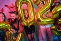 Friends having fun at New Year party, holding giant balloons 2023 Royalty Free Stock Photo