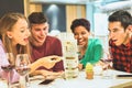 Group of young friends having fun playing board game in pub wine shop - Multiracial cheerful people smiling and enjoying time Royalty Free Stock Photo
