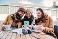 Group of young friends having fun watching videos on a social media app using a cellphone device it a coffee shop Royalty Free Stock Photo