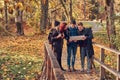 Group of young friends hiking in autumn colorful forest, looking at map and planning hike. Royalty Free Stock Photo