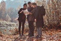 Group of young friends hiking in autumn colorful forest, looking at map and planning hike. Royalty Free Stock Photo