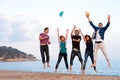 Group of young friends jumping on beach. Royalty Free Stock Photo