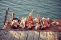 Group of young friends laying on a wooden jetty by water, sunbathing. Young men and women on summer vacation. Holiday, fun, Royalty Free Stock Photo