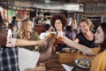 Group Of Young Friends Meeting For Drinks And Food Making A Toast In Restaurant