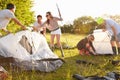 Group Of Young Friends Pitching Tents On Camping Holiday