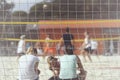 Group of young friends playing beach volleyball, unrecognizable girl fans back to us, summer day, selectiv focus