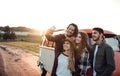 A group of young friends on a roadtrip through countryside, taking selfie. Royalty Free Stock Photo