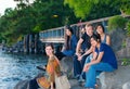 Group of young friends sitting on rocks by lake Royalty Free Stock Photo