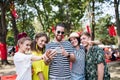 Group of young friends with smartphone at summer festival, taking selfie. Royalty Free Stock Photo