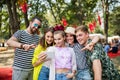 Group of young friends with smartphone at summer festival, taking selfie. Royalty Free Stock Photo