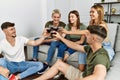 Group of young friends smiling happy toasting with glass of red wine at home Royalty Free Stock Photo