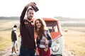 A group of young friends on a roadtrip through countryside, taking selfie. Royalty Free Stock Photo