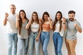 Group of young friends standing together over isolated background angry and mad raising fist frustrated and furious while shouting Royalty Free Stock Photo