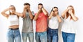 Group of young friends standing together over isolated background covering eyes and mouth with hands, surprised and shocked Royalty Free Stock Photo