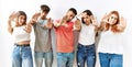 Group of young friends standing together over isolated background doing frame using hands palms and fingers, camera perspective Royalty Free Stock Photo