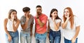 Group of young friends standing together over isolated background hand on mouth telling secret rumor, whispering malicious talk Royalty Free Stock Photo