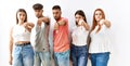 Group of young friends standing together over isolated background looking unhappy and angry showing rejection and negative with Royalty Free Stock Photo