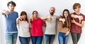 Group of young friends standing together over isolated background looking unhappy and angry showing rejection and negative with Royalty Free Stock Photo