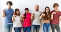 Group of young friends standing together over isolated background pointing down looking sad and upset, indicating direction with Royalty Free Stock Photo