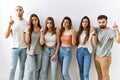 Group of young friends standing together over isolated background pointing up looking sad and upset, indicating direction with Royalty Free Stock Photo