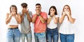 Group of young friends standing together over isolated background shocked covering mouth with hands for mistake Royalty Free Stock Photo