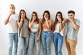 Group of young friends standing together over isolated background shocked covering mouth with hands for mistake Royalty Free Stock Photo