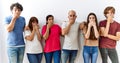 Group of young friends standing together over isolated background shocked covering mouth with hands for mistake Royalty Free Stock Photo