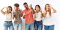 Group of young friends standing together over isolated background shouting frustrated with rage, hands trying to strangle, yelling Royalty Free Stock Photo