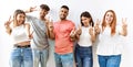 Group of young friends standing together over isolated background smiling with tongue out showing fingers of both hands doing Royalty Free Stock Photo