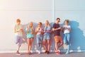 Group of young friends using their mobile phones in front of a wall Royalty Free Stock Photo