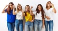 Group of young girl friends standing together over isolated background angry and mad raising fist frustrated and furious while Royalty Free Stock Photo