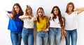 Group of young girl friends standing together over isolated background looking unhappy and angry showing rejection and negative Royalty Free Stock Photo