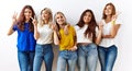 Group of young girl friends standing together over isolated background smiling looking to the camera showing fingers doing victory Royalty Free Stock Photo